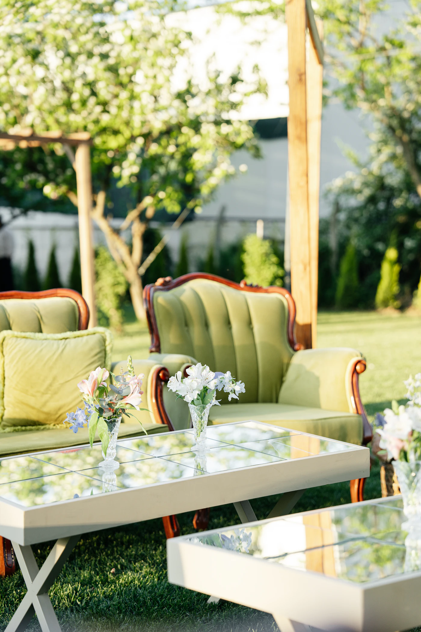 Vintage furniture rentals for eclectic reception spaces — Mismatched antique chairs surround a long farmhouse table set for dinner.