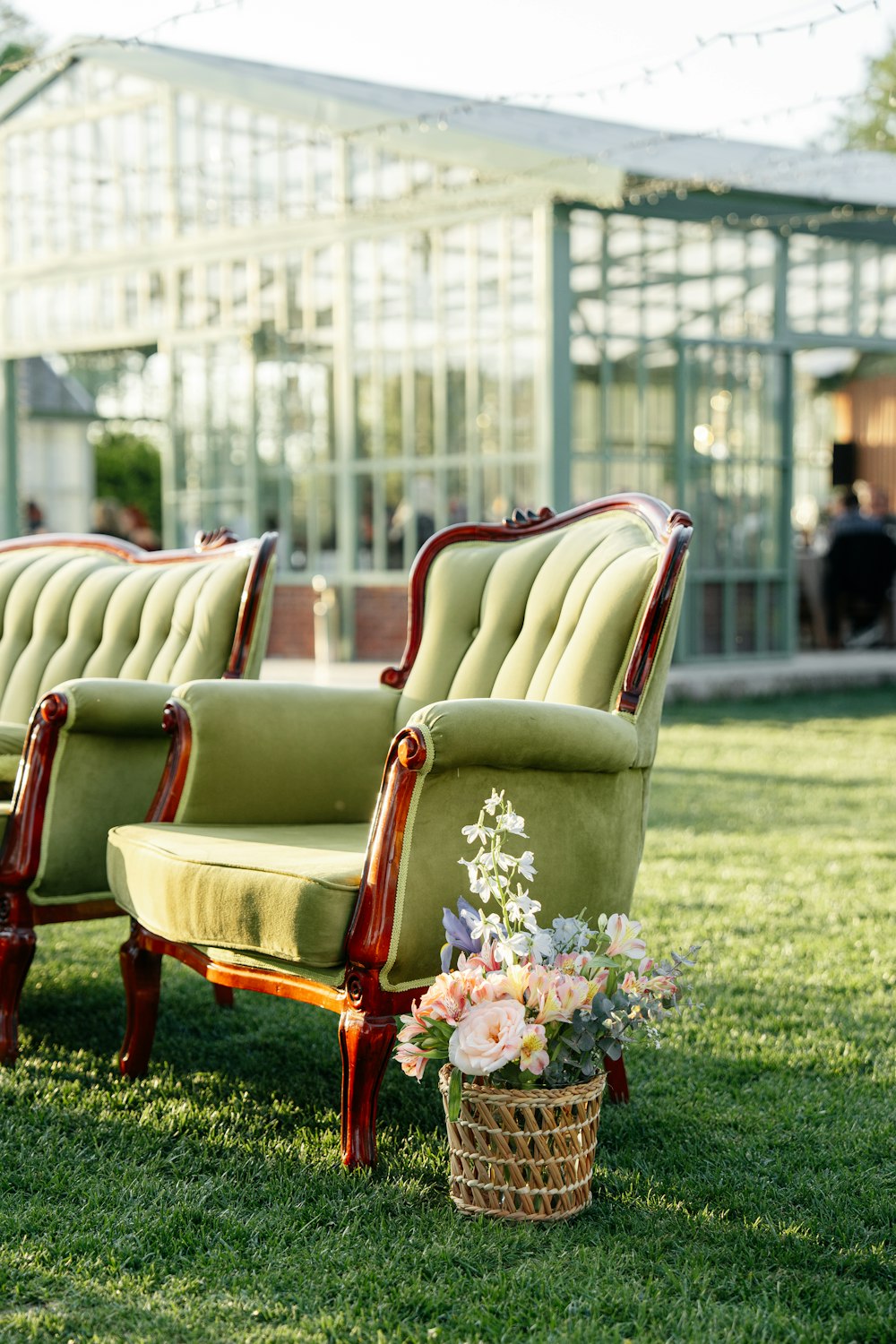 a row of green chairs sitting on top of a lush green field