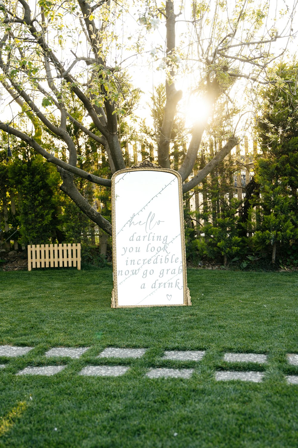 a white sign sitting in the middle of a lush green field