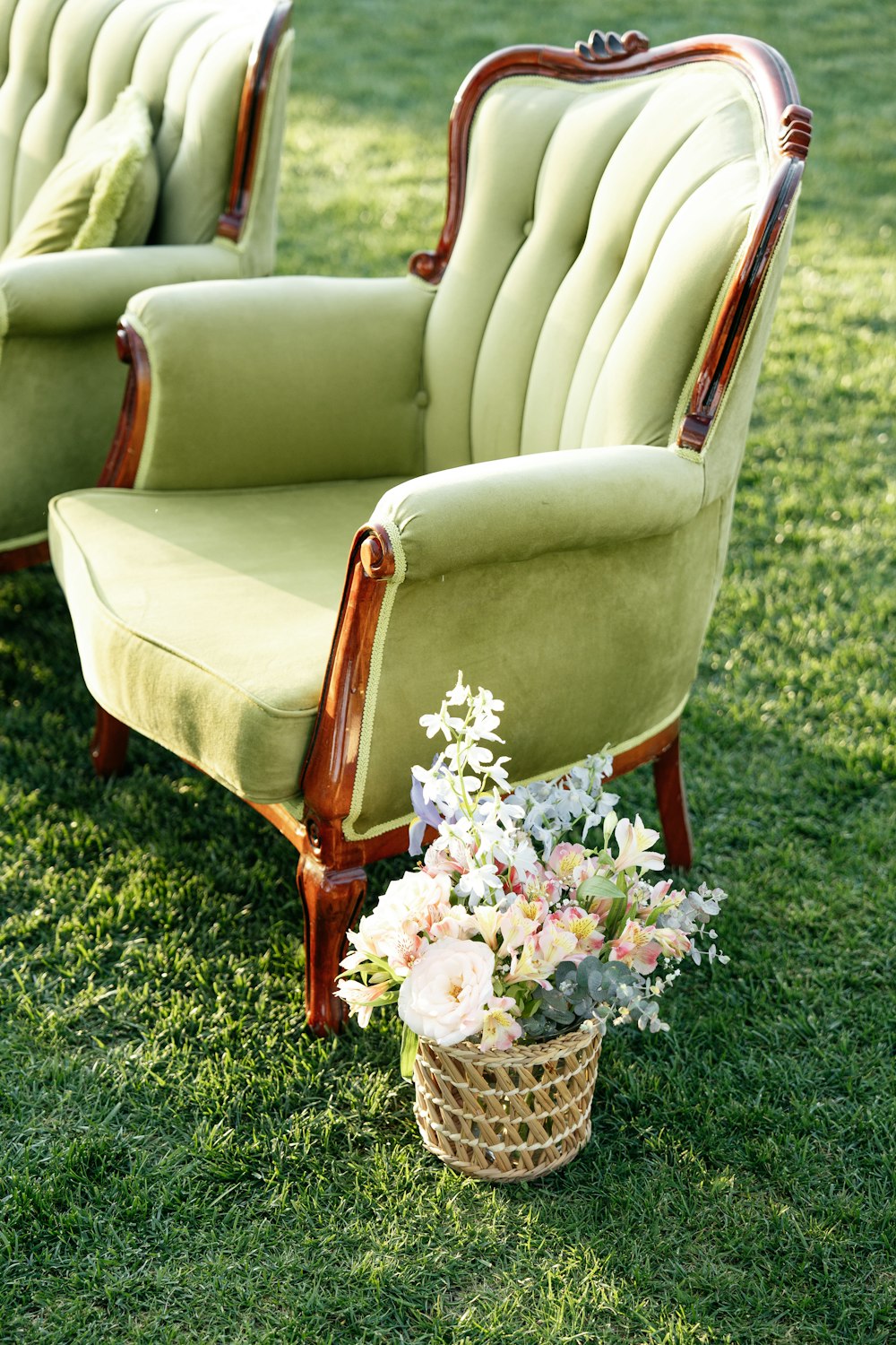 a couple of green chairs sitting on top of a lush green field