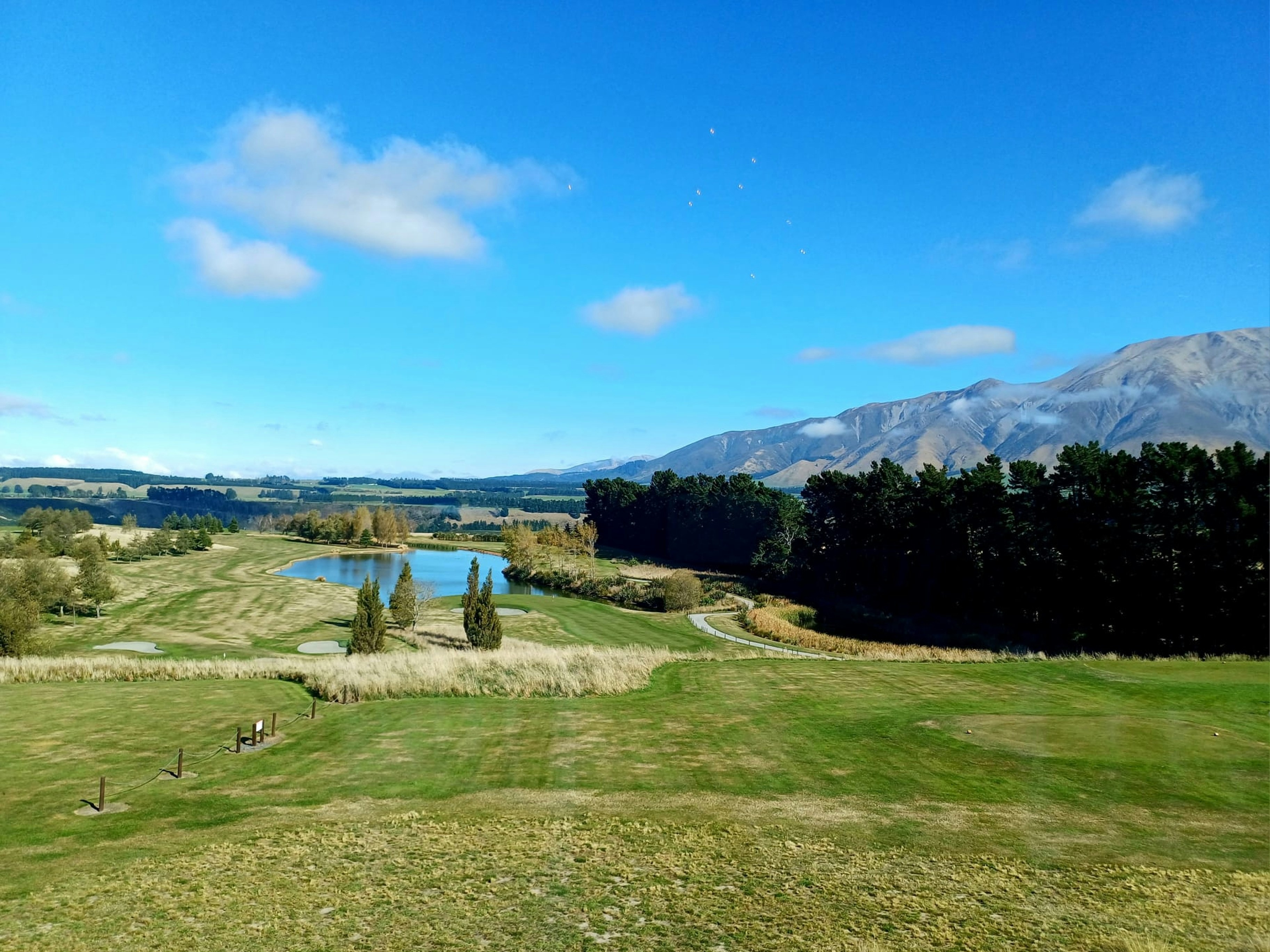 a view of a golf course with a lake in the distance