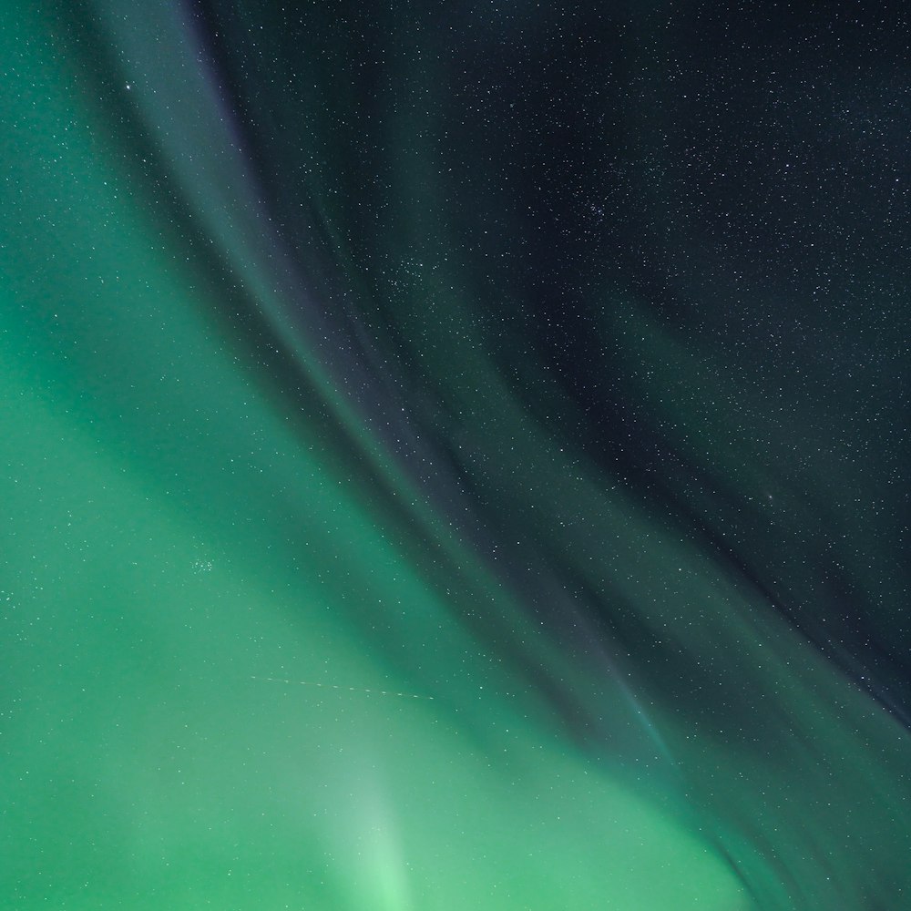 a green and blue aurora bore is in the sky