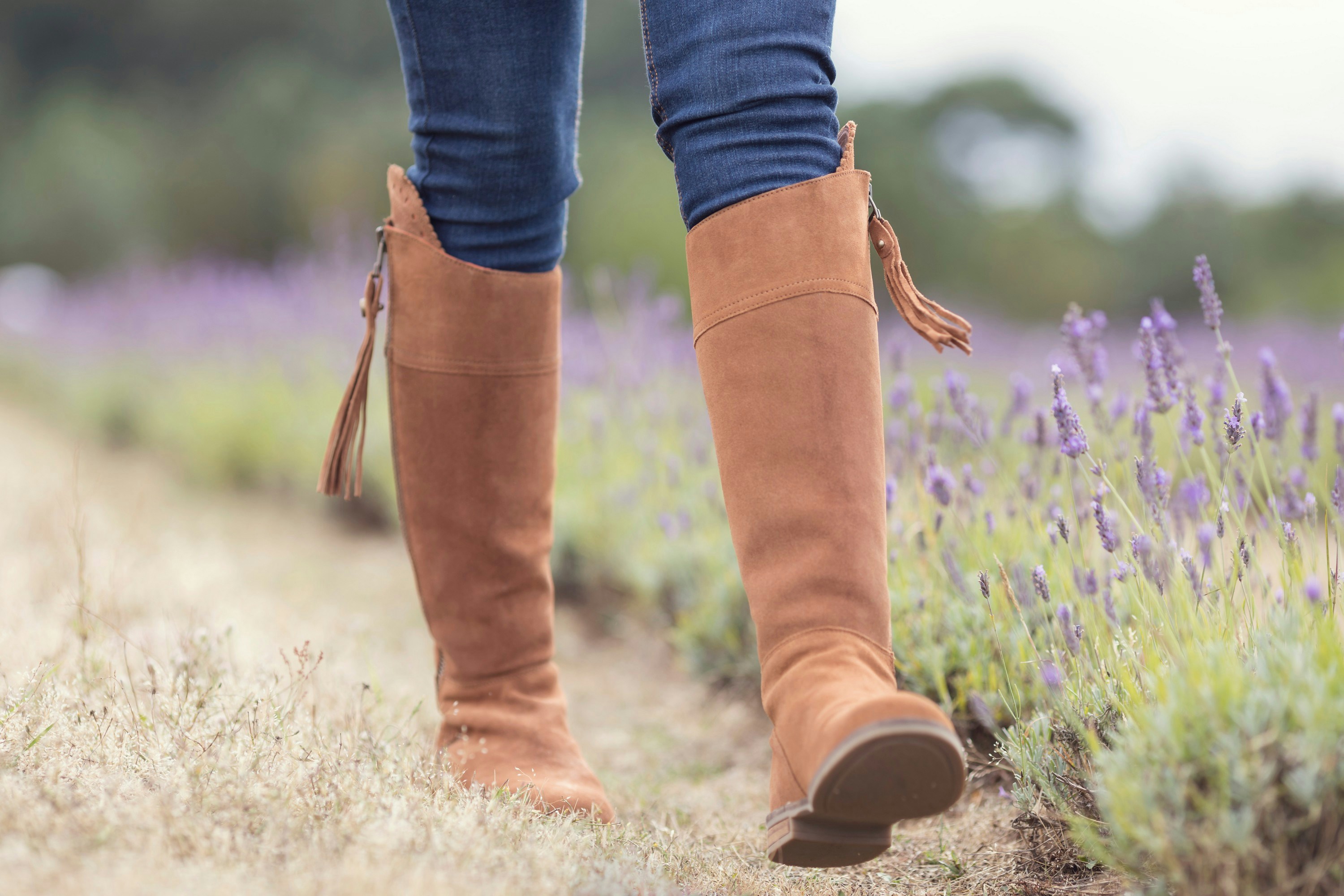 Un primer plano de las botas de una persona en un campo de flores