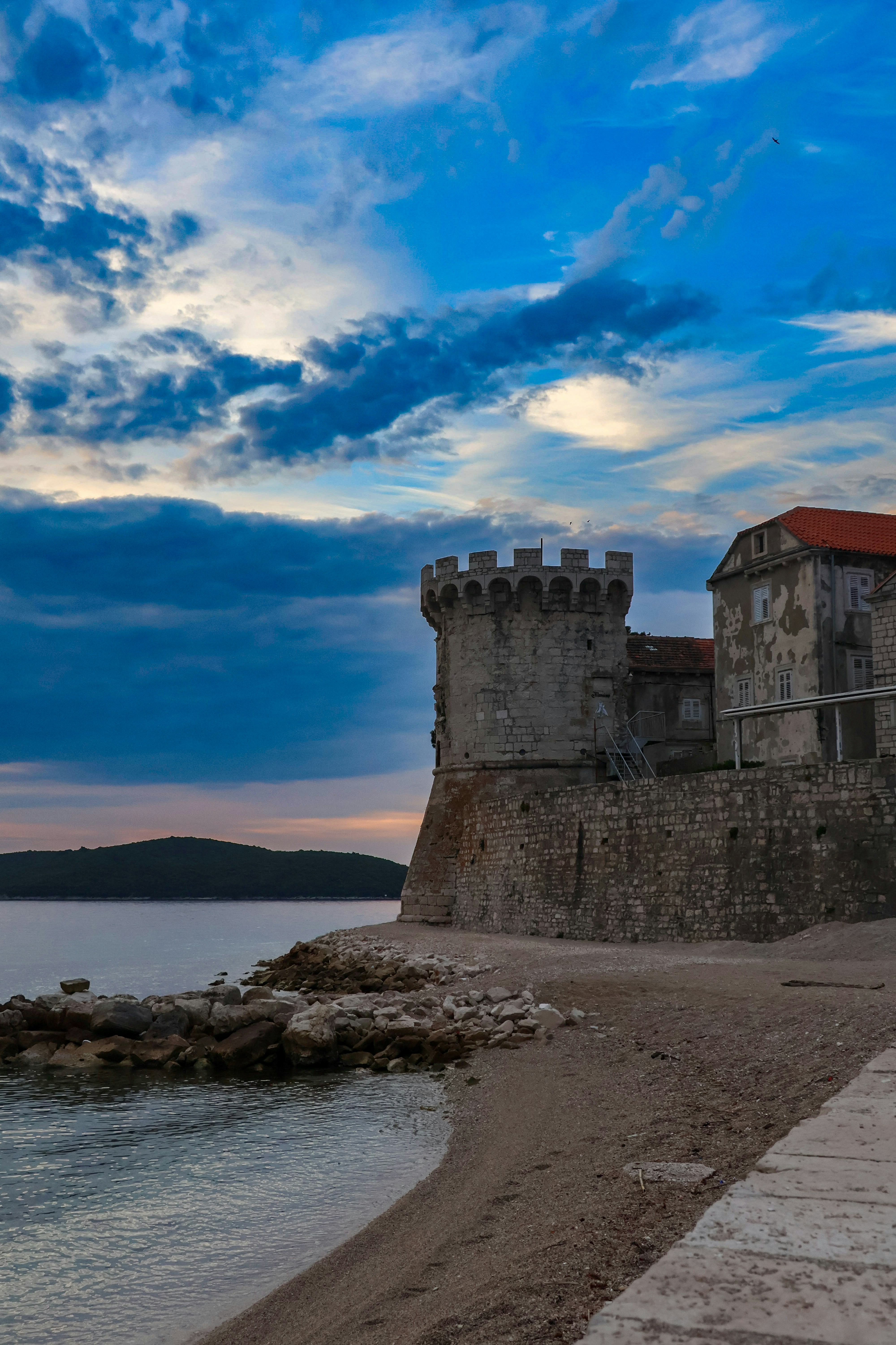 a castle sitting on top of a beach next to a body of water