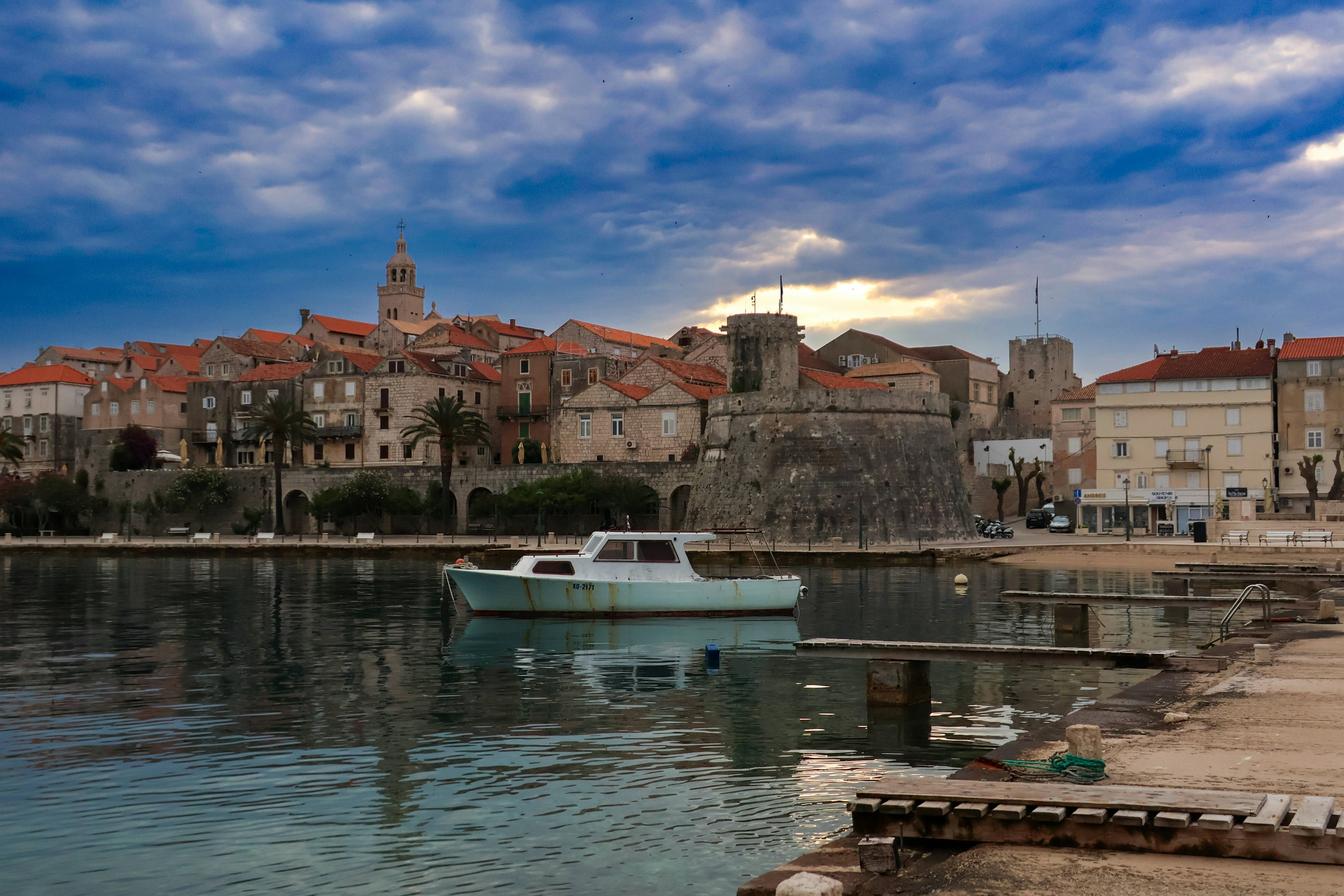 a small boat in the water near a city