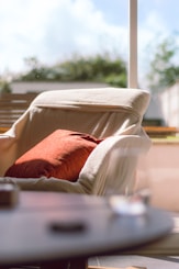 a chair with a pillow on it in front of a window