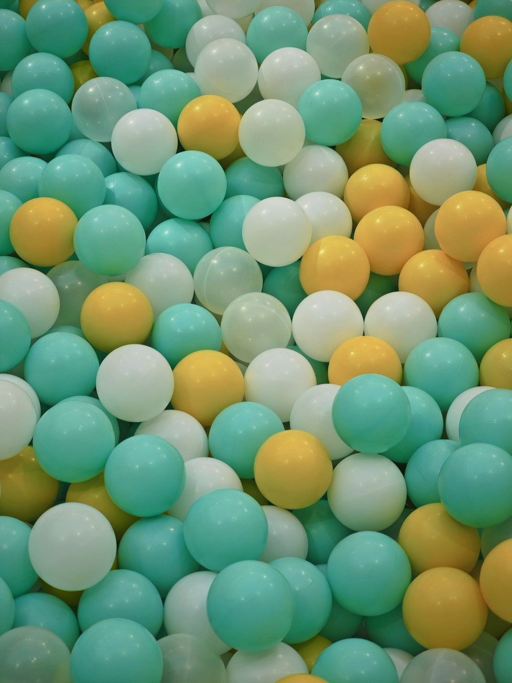 a bunch of balloons that are blue, yellow, and white