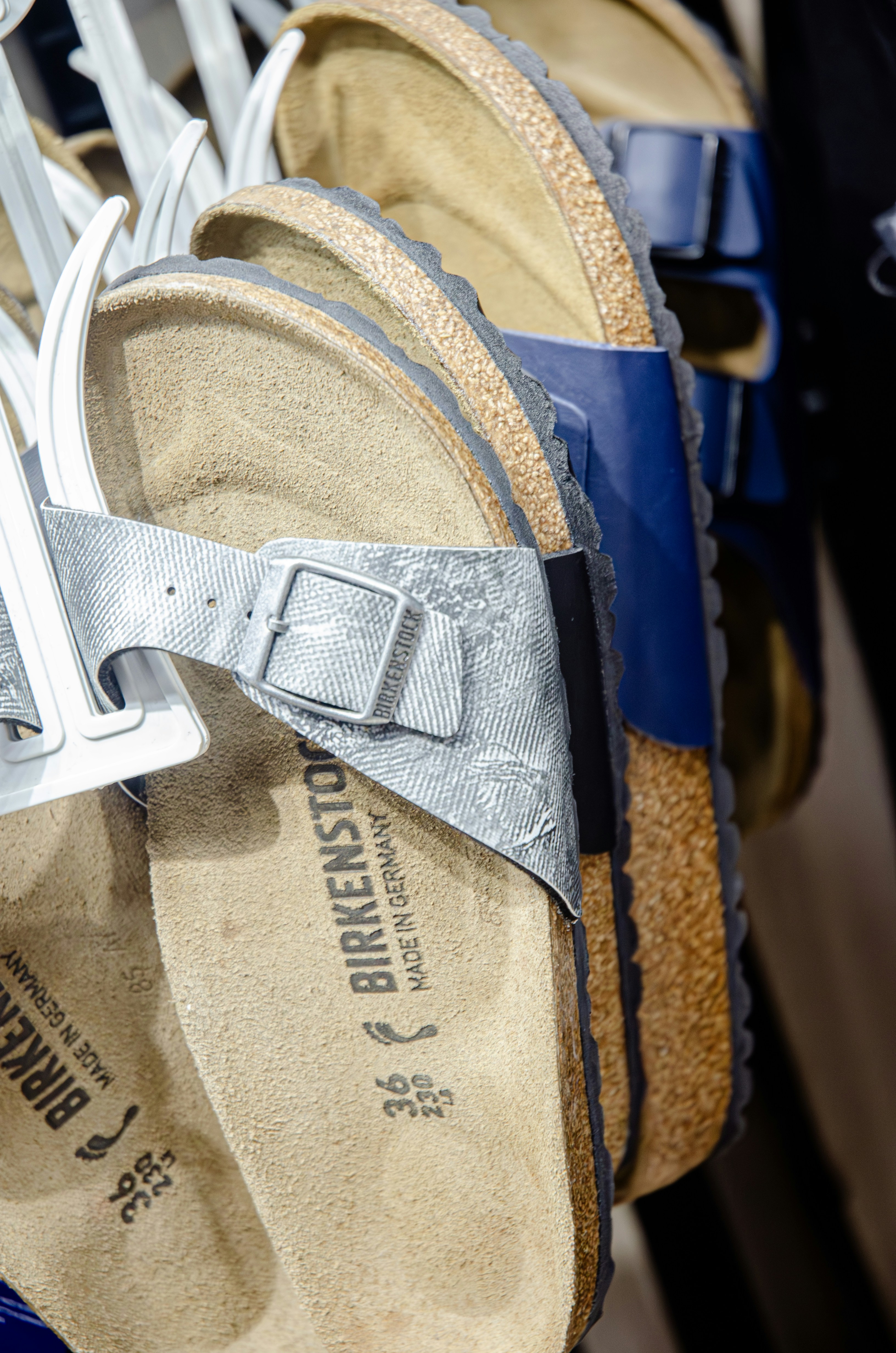 a pair of blue and silver sandals on a rack