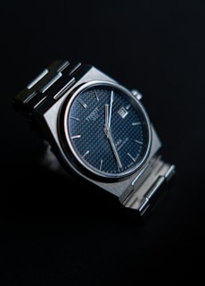 a close up of a watch on a black surface