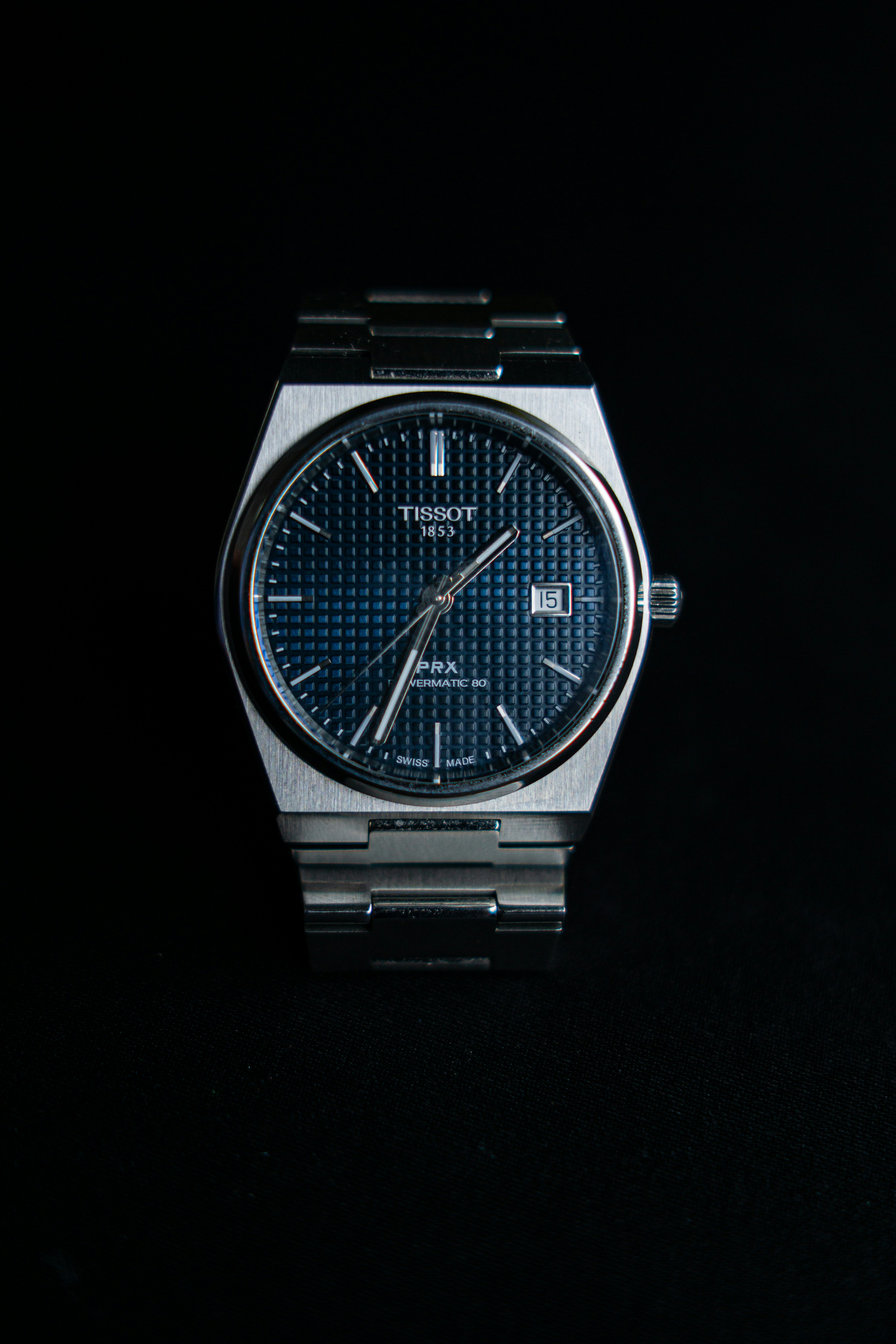 a watch sitting on top of a black surface