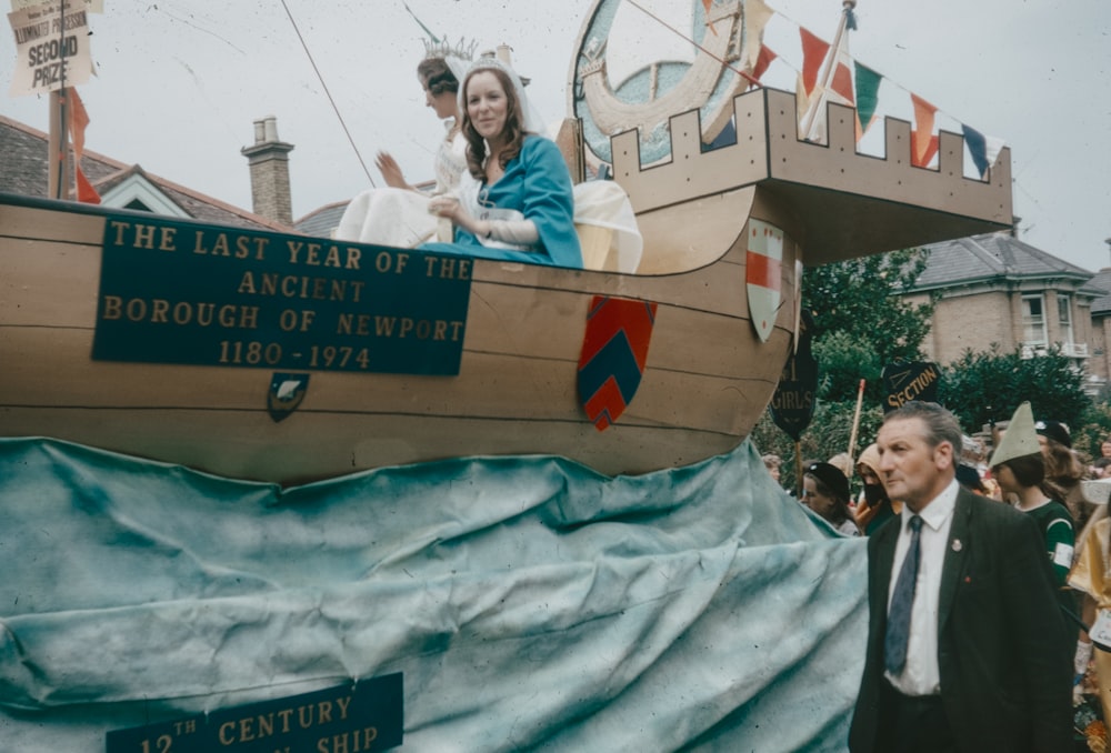 a man and a woman standing in front of a boat