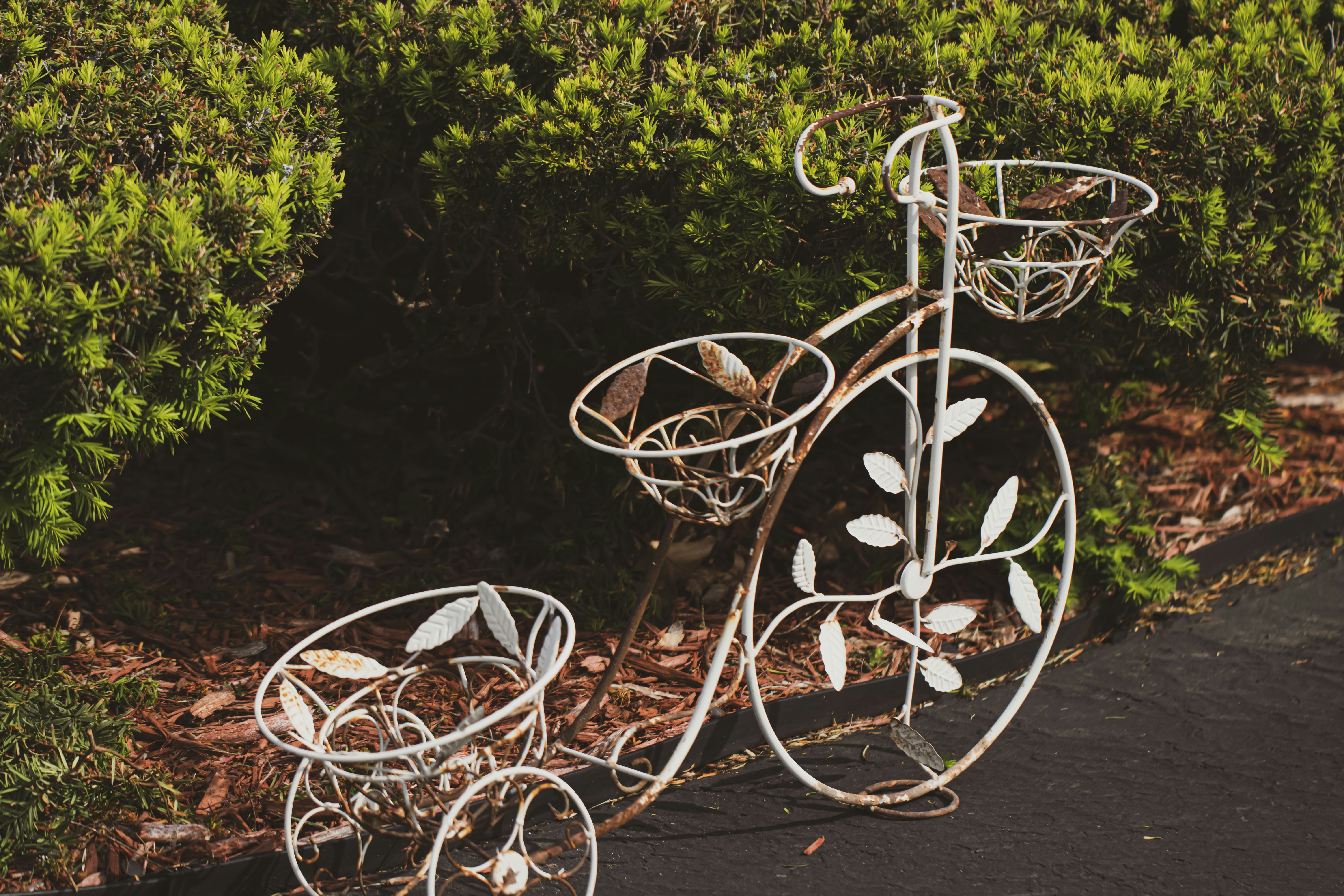 a metal sculpture of a bicycle on the side of a road