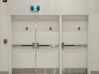a white room with two doors and some signs on the doors