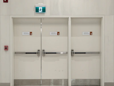 a white room with two doors and some signs on the doors