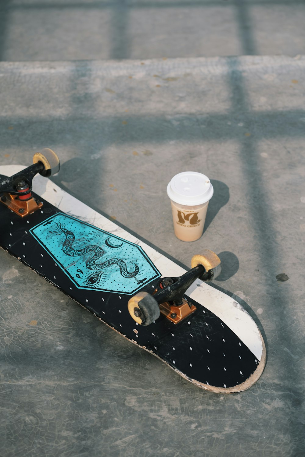 a skateboard and a cup of coffee on the ground