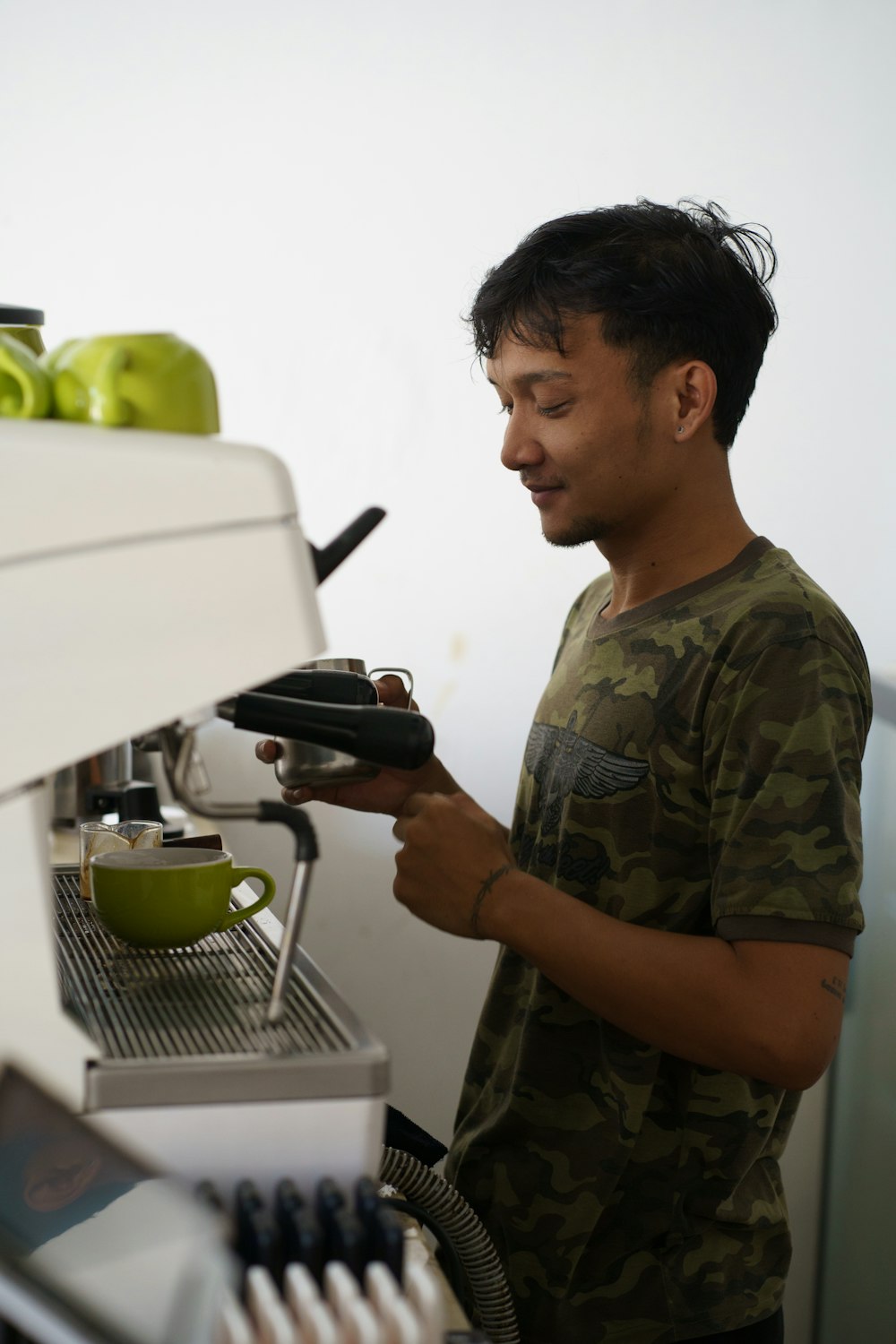a man standing next to a machine filled with green apples