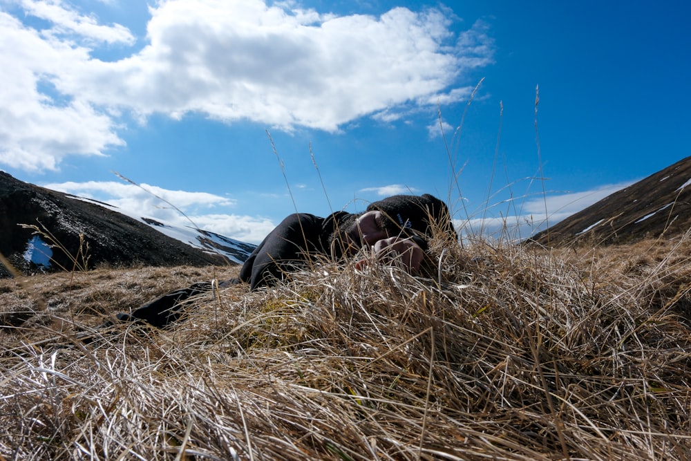 a person laying in the grass with a sky background