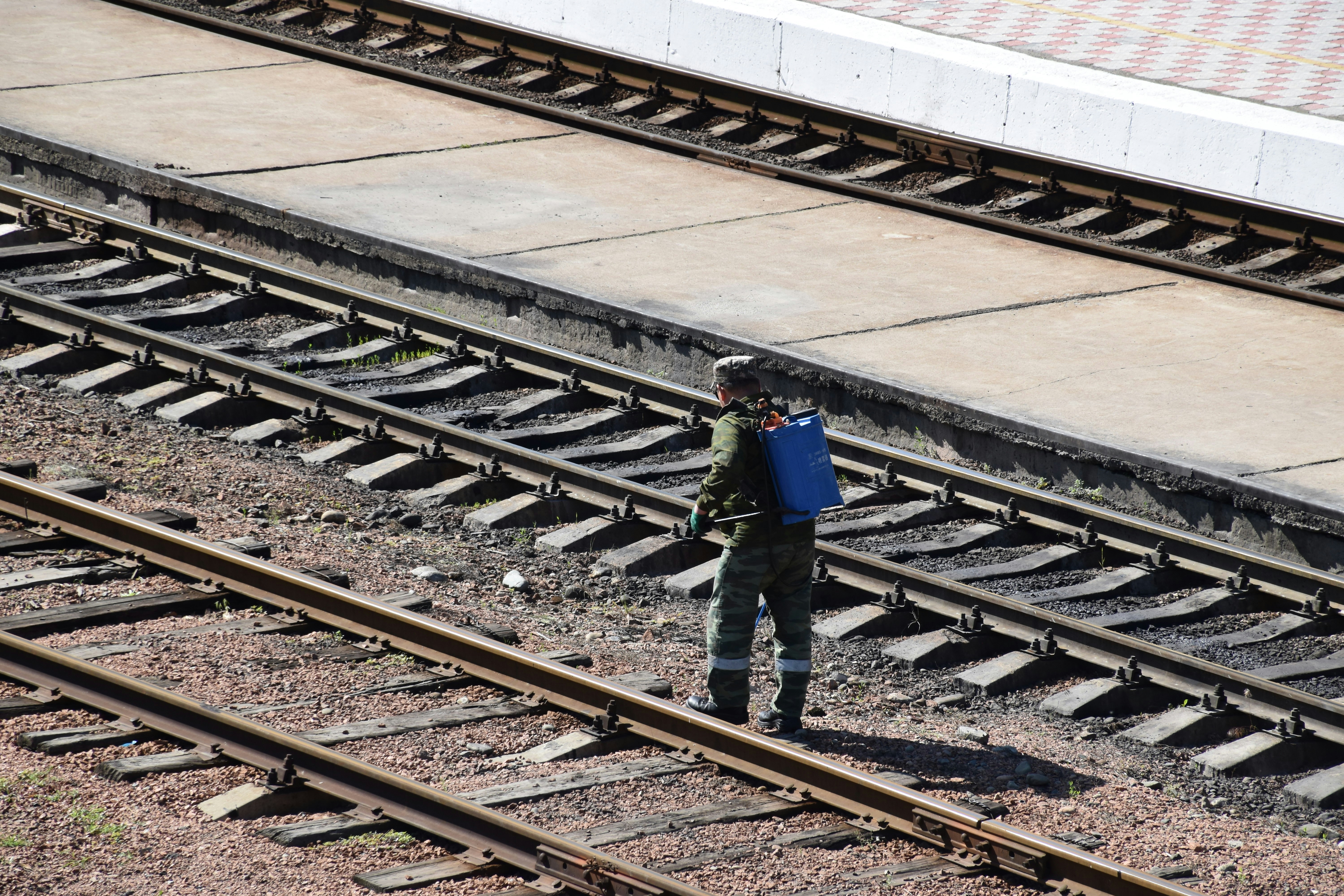 a person with a backpack standing on a train track