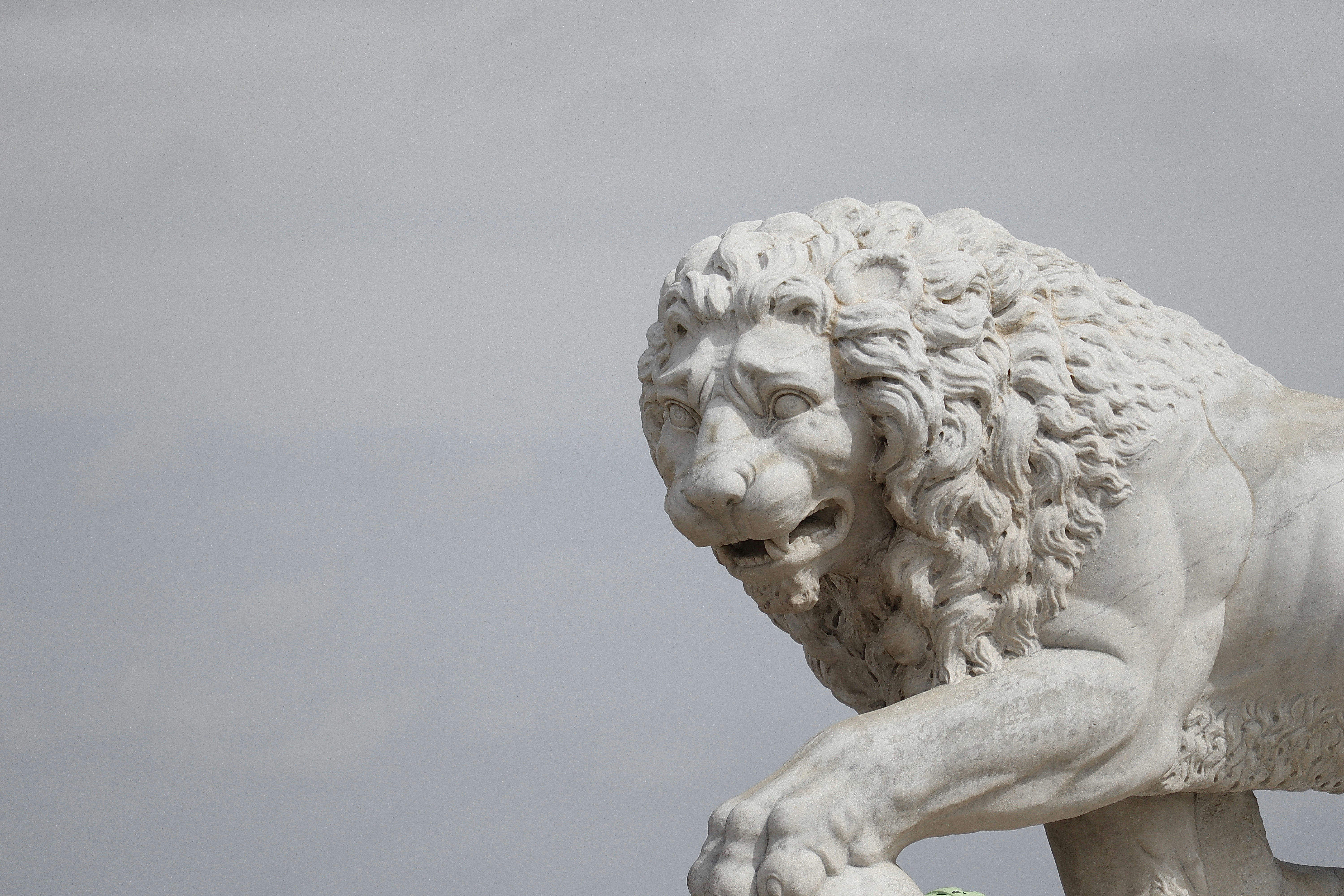 a statue of a lion holding a soccer ball