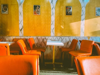 a restaurant with orange chairs and a white table