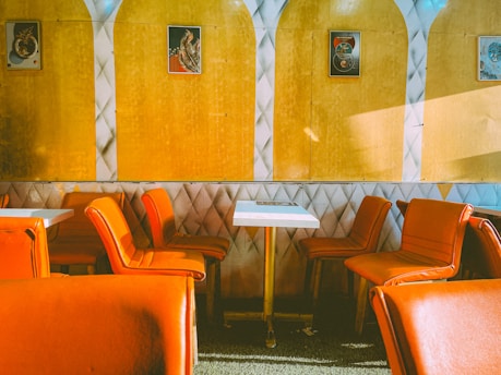a restaurant with orange chairs and a white table