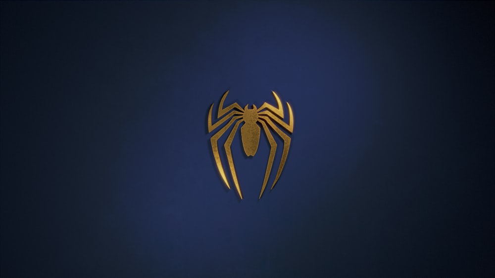 a golden spider logo on a dark blue background