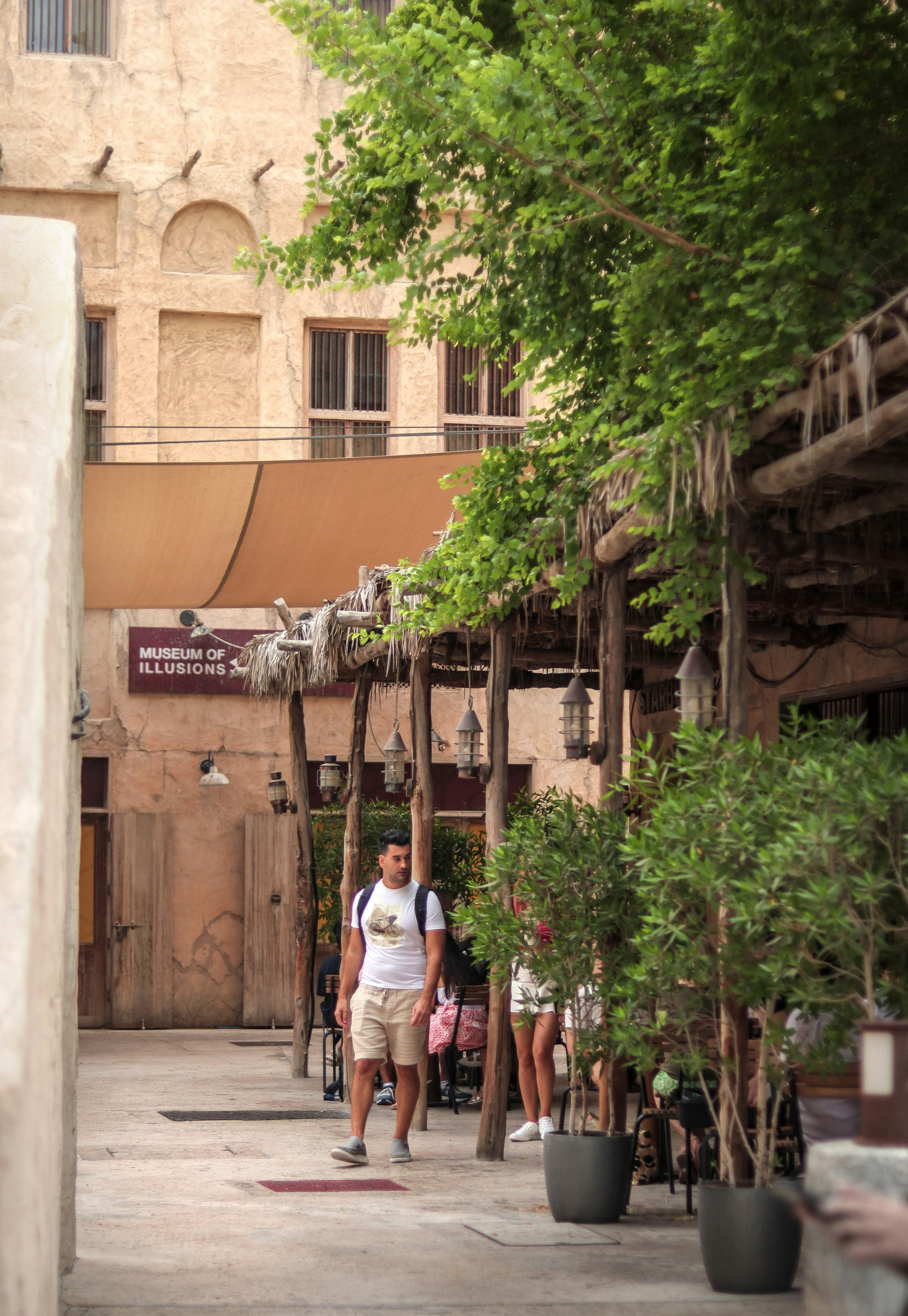 a man walking down a street next to a tall building