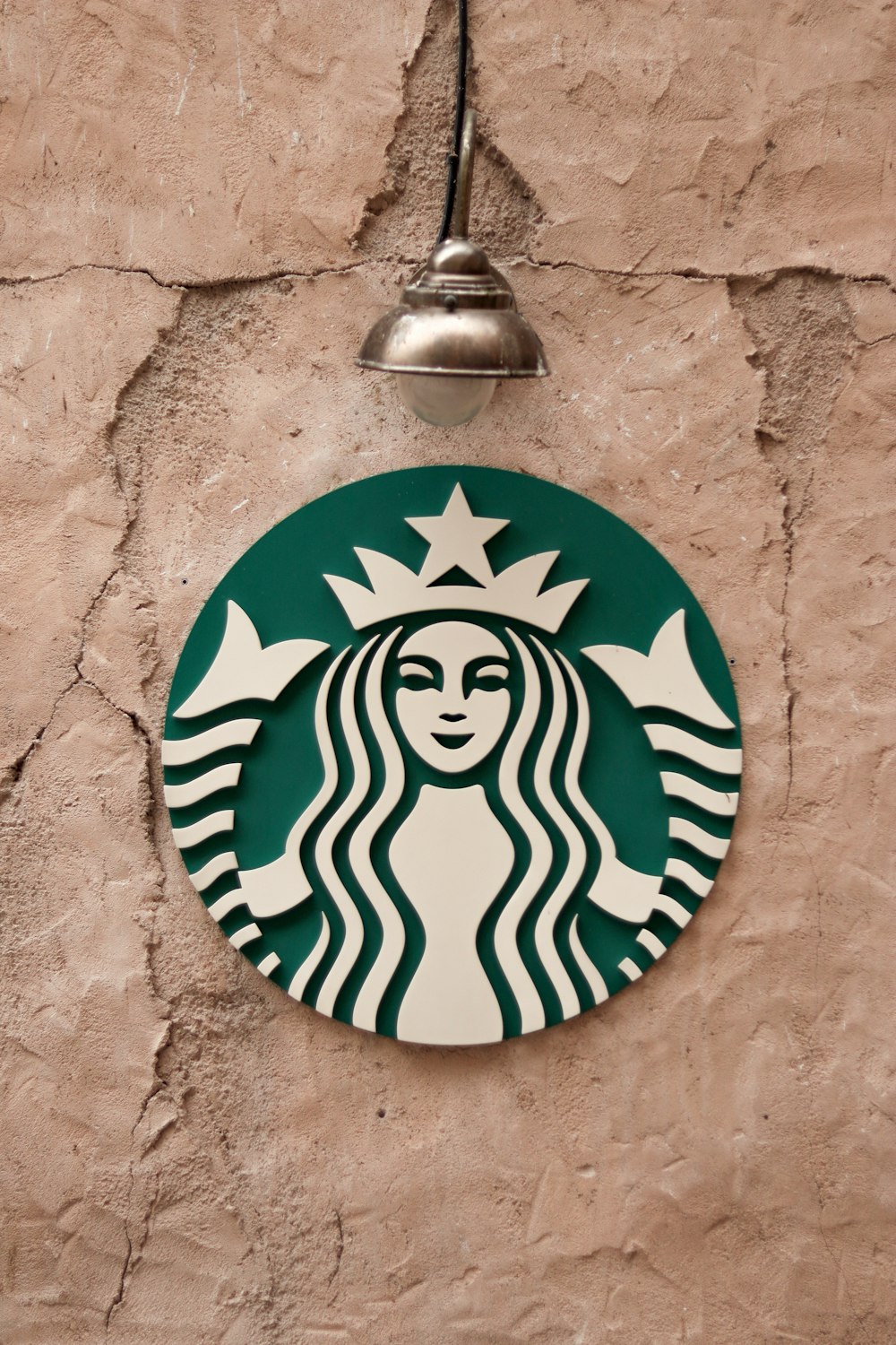 a starbucks sign hanging on a wall