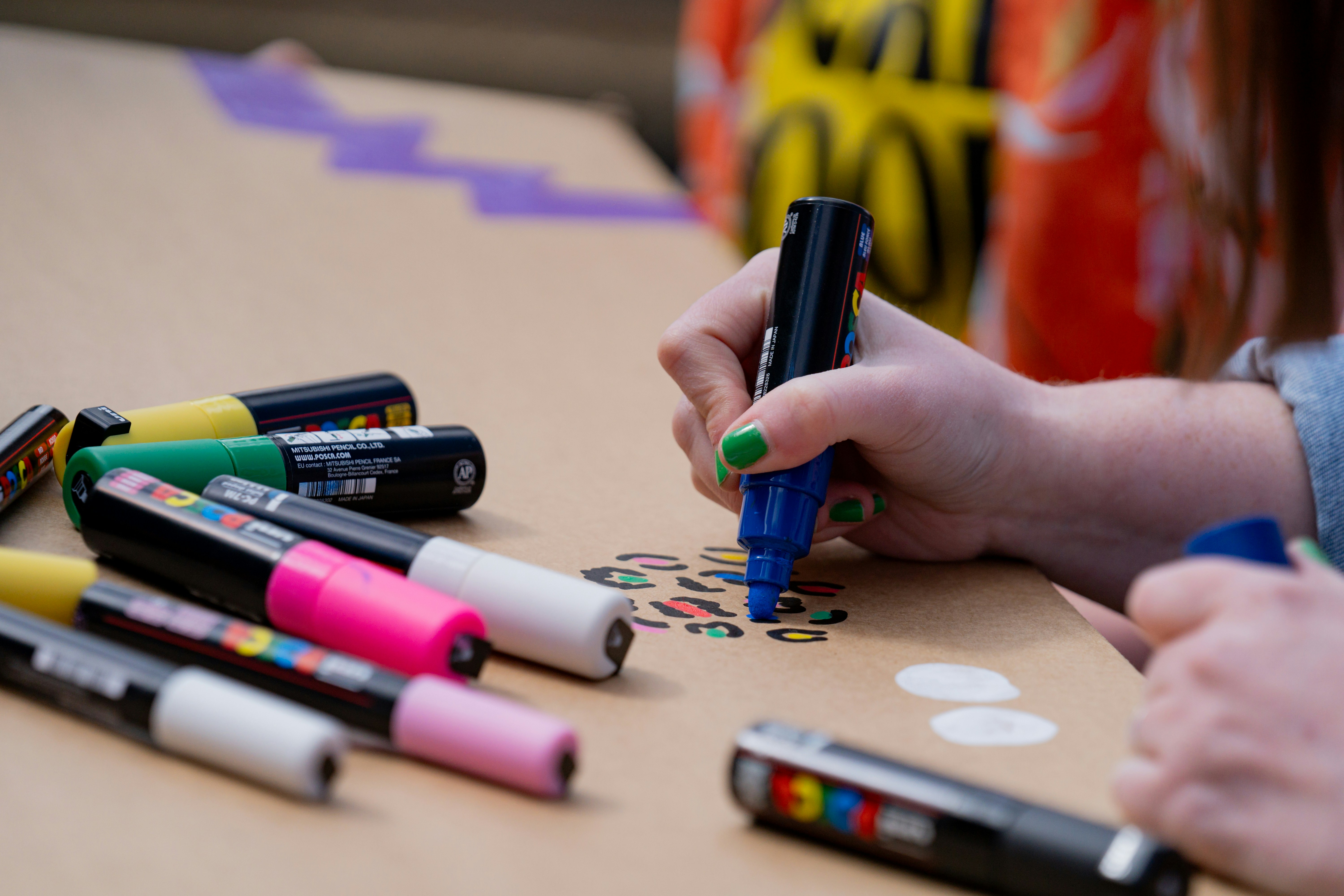 a person holding a pen and writing on a piece of paper