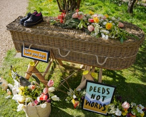 a display of flowers and shoes on display in a garden