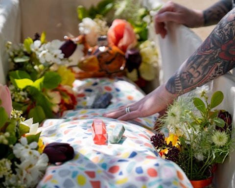 a spiritual farewell, body wraped in a colourful shroud, cystals and  flowers in the coffin
