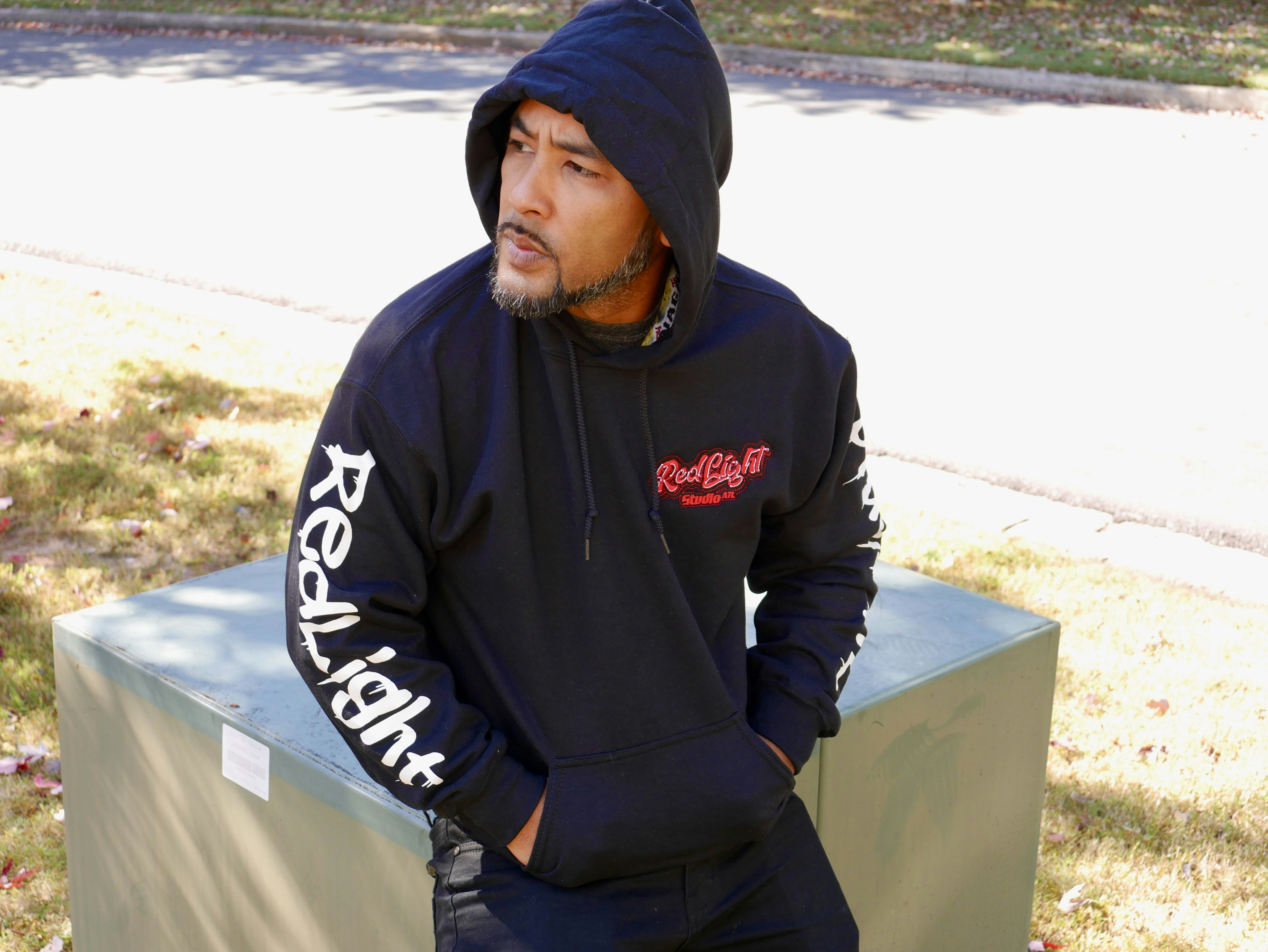 a man sitting on a bench wearing a hoodie