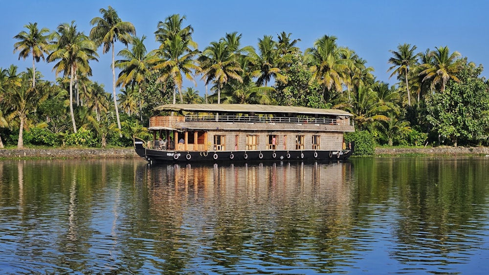 a house boat on a river with palm trees in the background