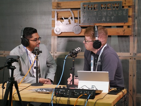 Two men recording a podcast with microphones and microphones.