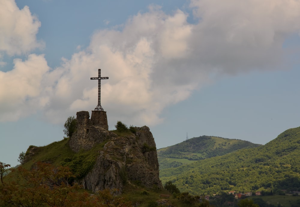 a cross on top of a hill with a sky background