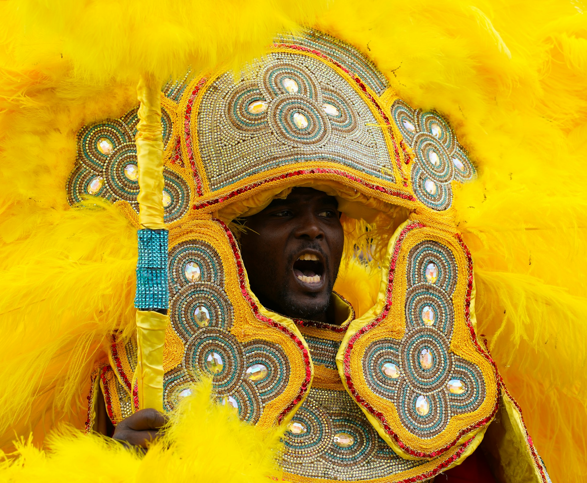 a man in a yellow costume with feathers on his head