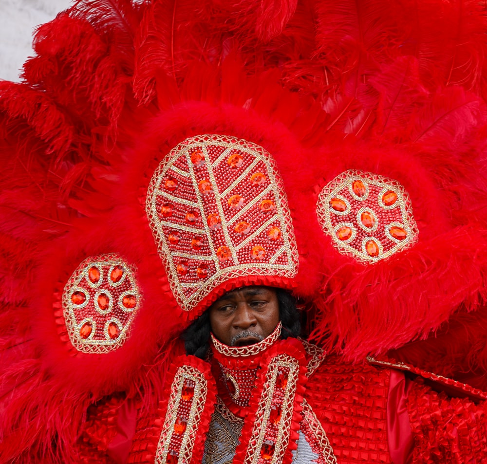 a man in a red costume with feathers on his head