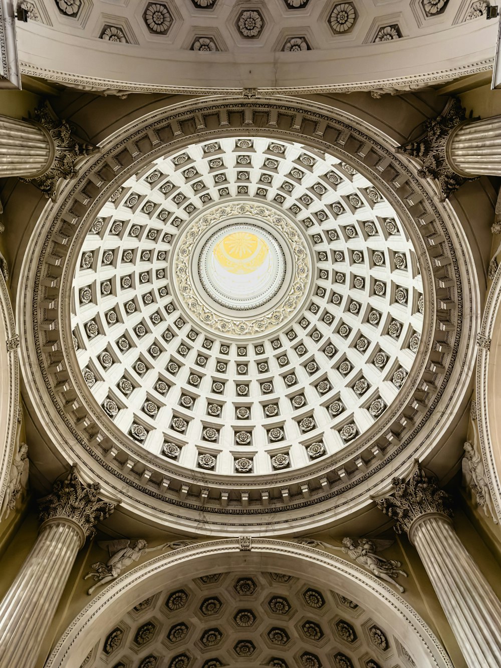 the ceiling of a building with columns and a dome