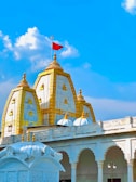 a white and gold building with a red flag on top