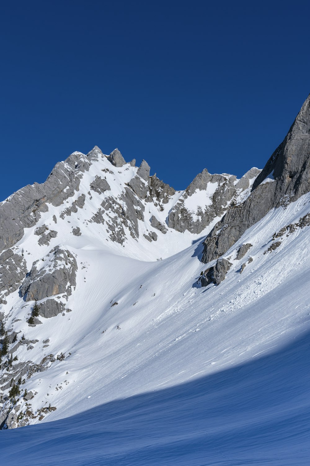 Ein Mann fährt Skier einen schneebedeckten Hang hinunter