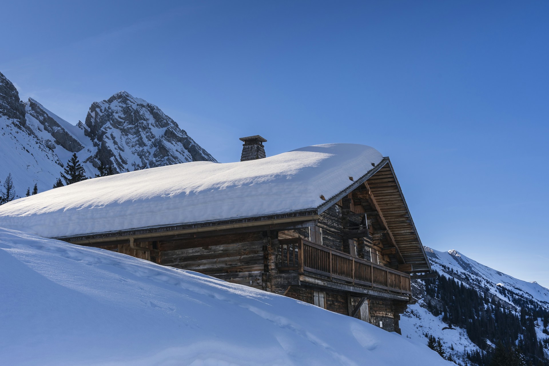 a cabin in the mountains covered in snow