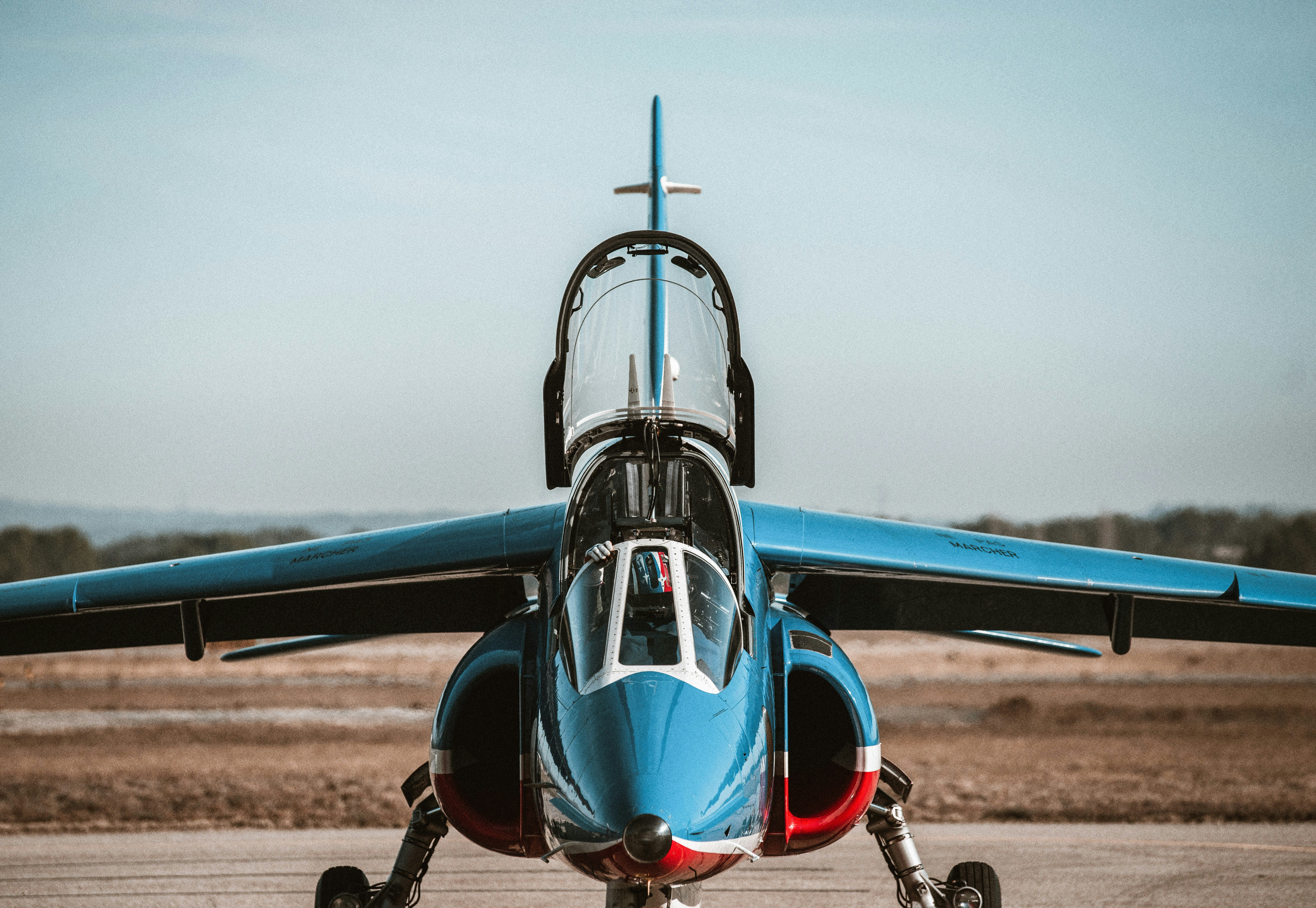 a blue and white jet sitting on top of an airport tarmac, 
