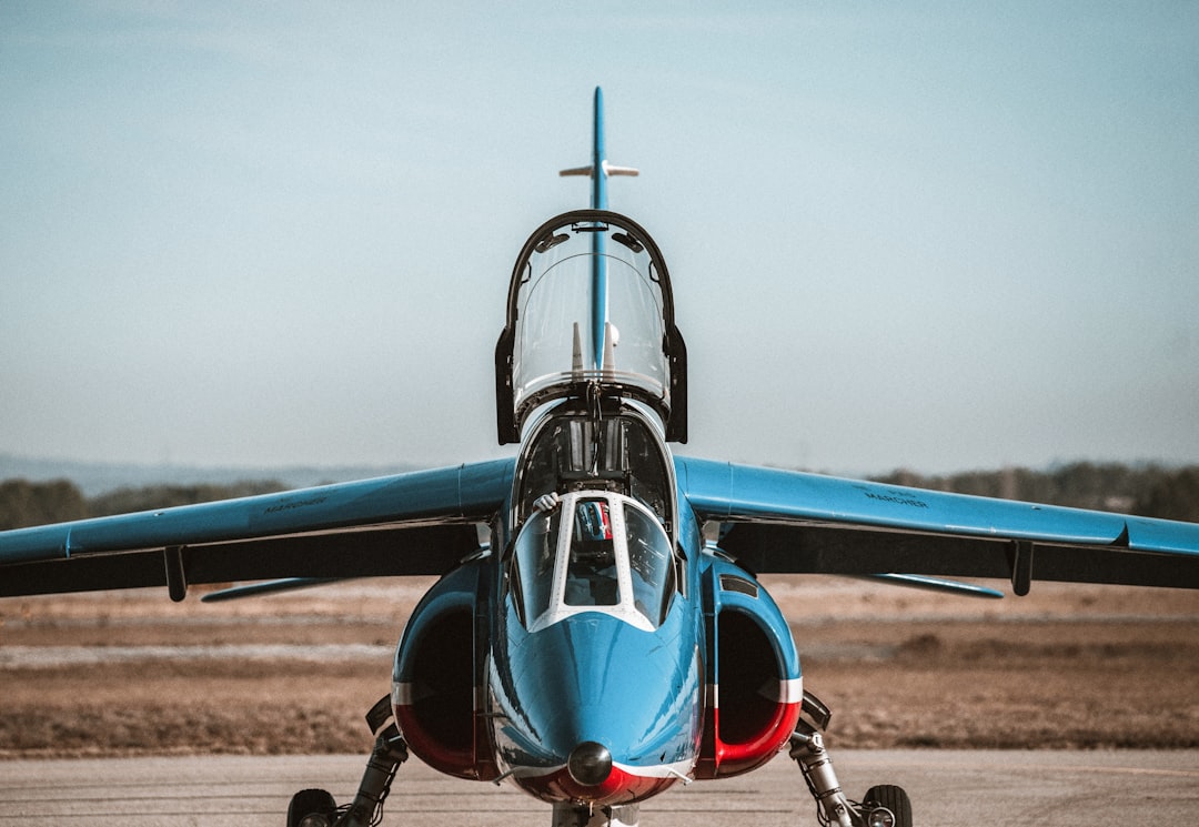 a blue and white jet sitting on top of an airport tarmac,