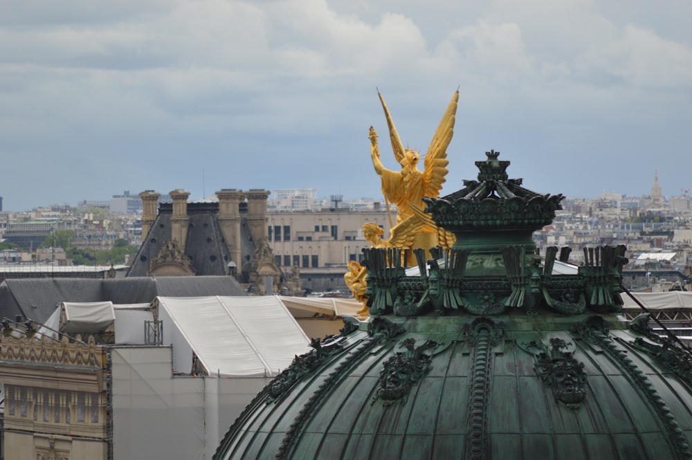 a view of a building with a green dome and gold statues on top