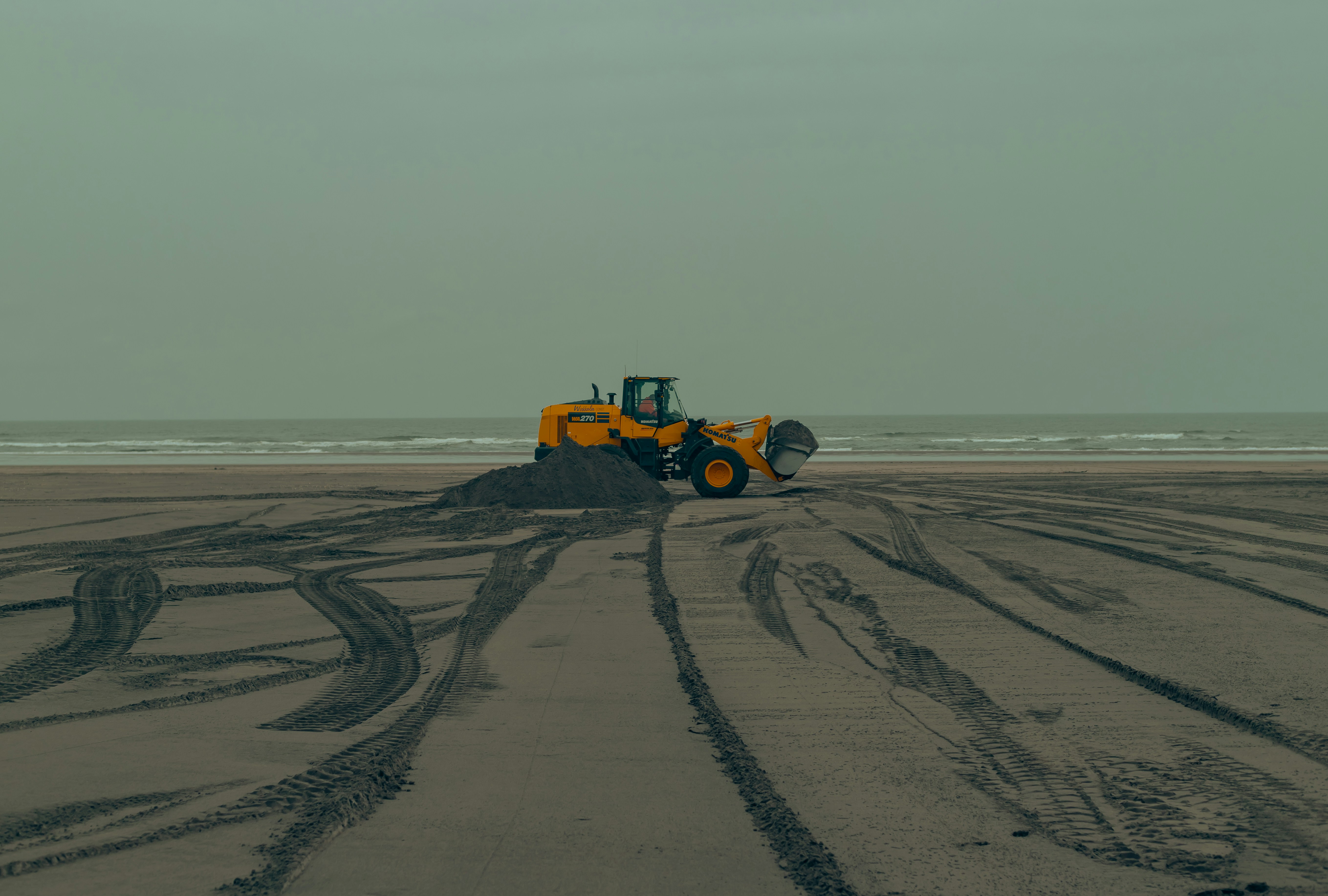 Ein Traktor ist an einem Strand in der Nähe des Ozeans geparkt