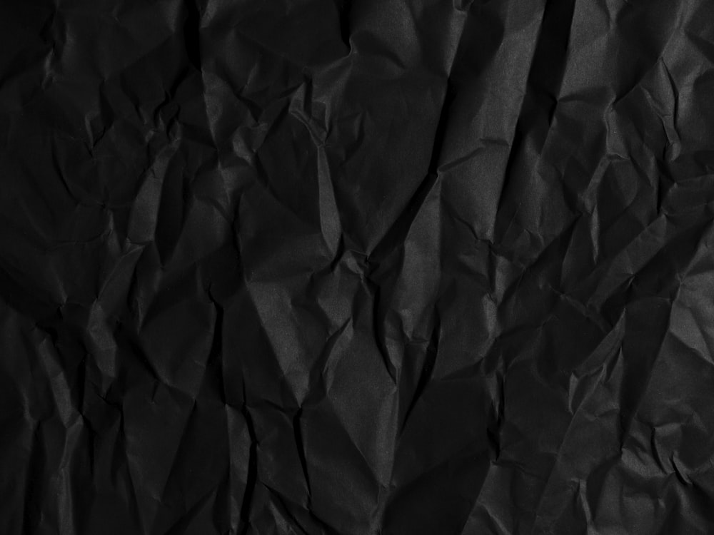 a black crumpled paper background with a black background