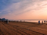 a group of people standing on top of a sandy beach