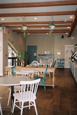 a restaurant with tables, chairs, and potted plants