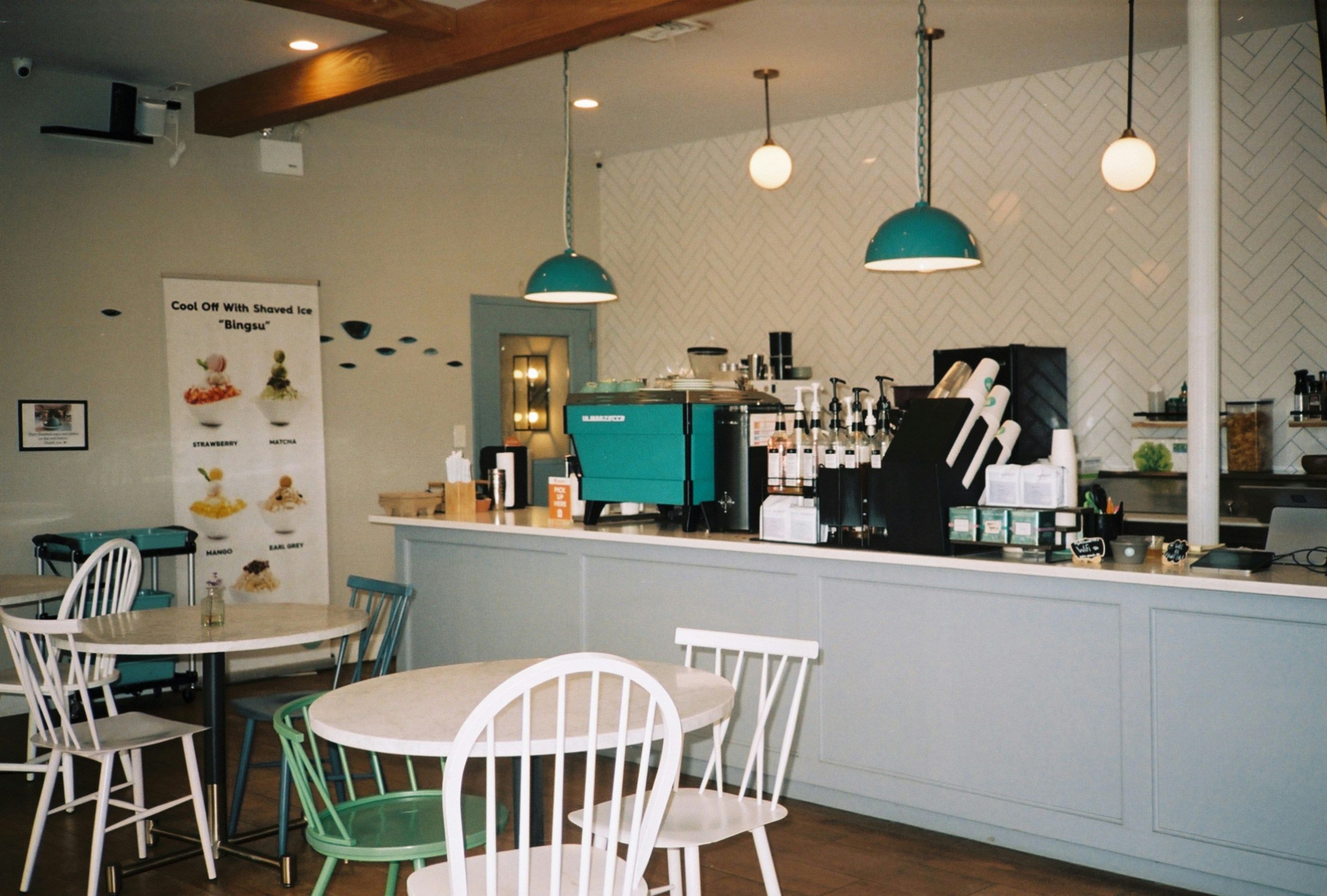 a coffee shop with tables and chairs around it