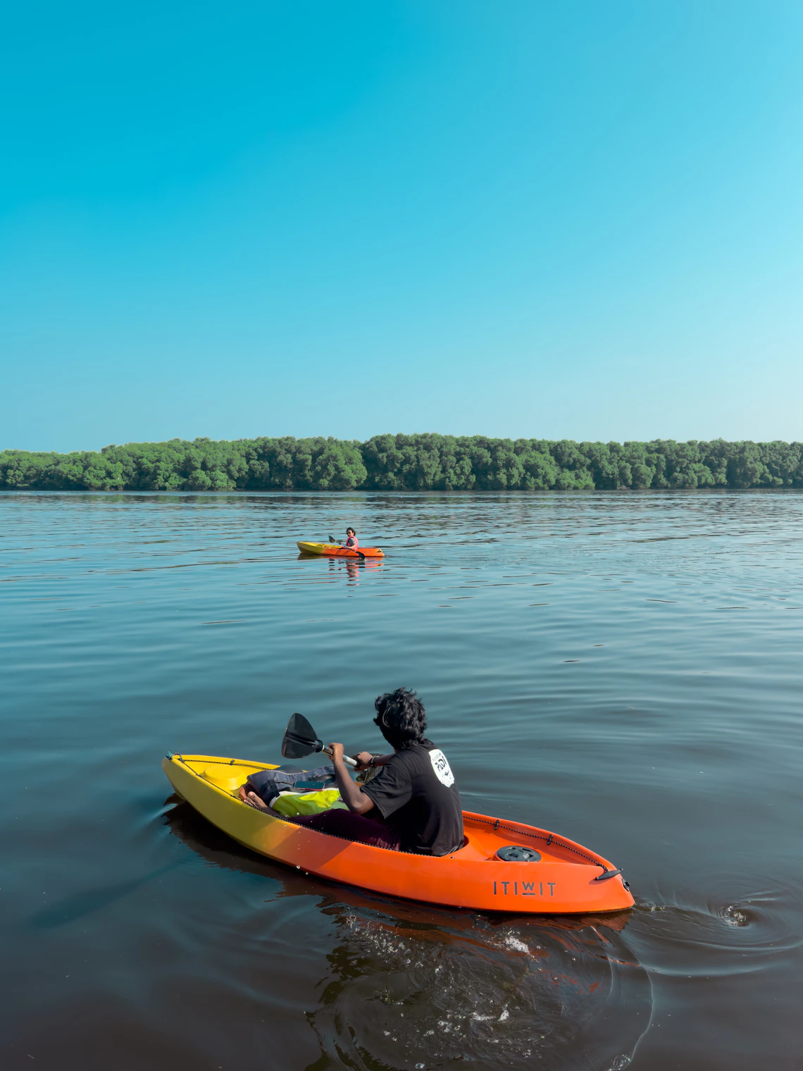 A kayaker paddling across a peaceful lake